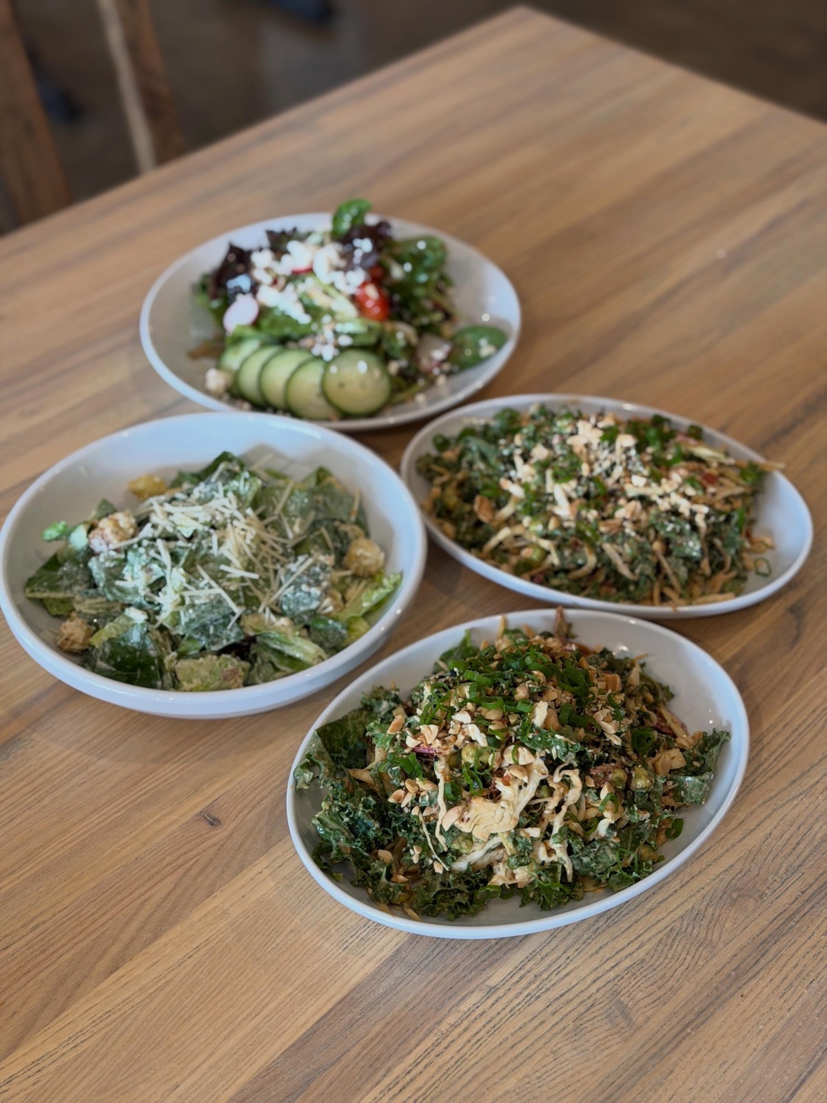 Fresh seasonal salads on a wood table at Market & Main