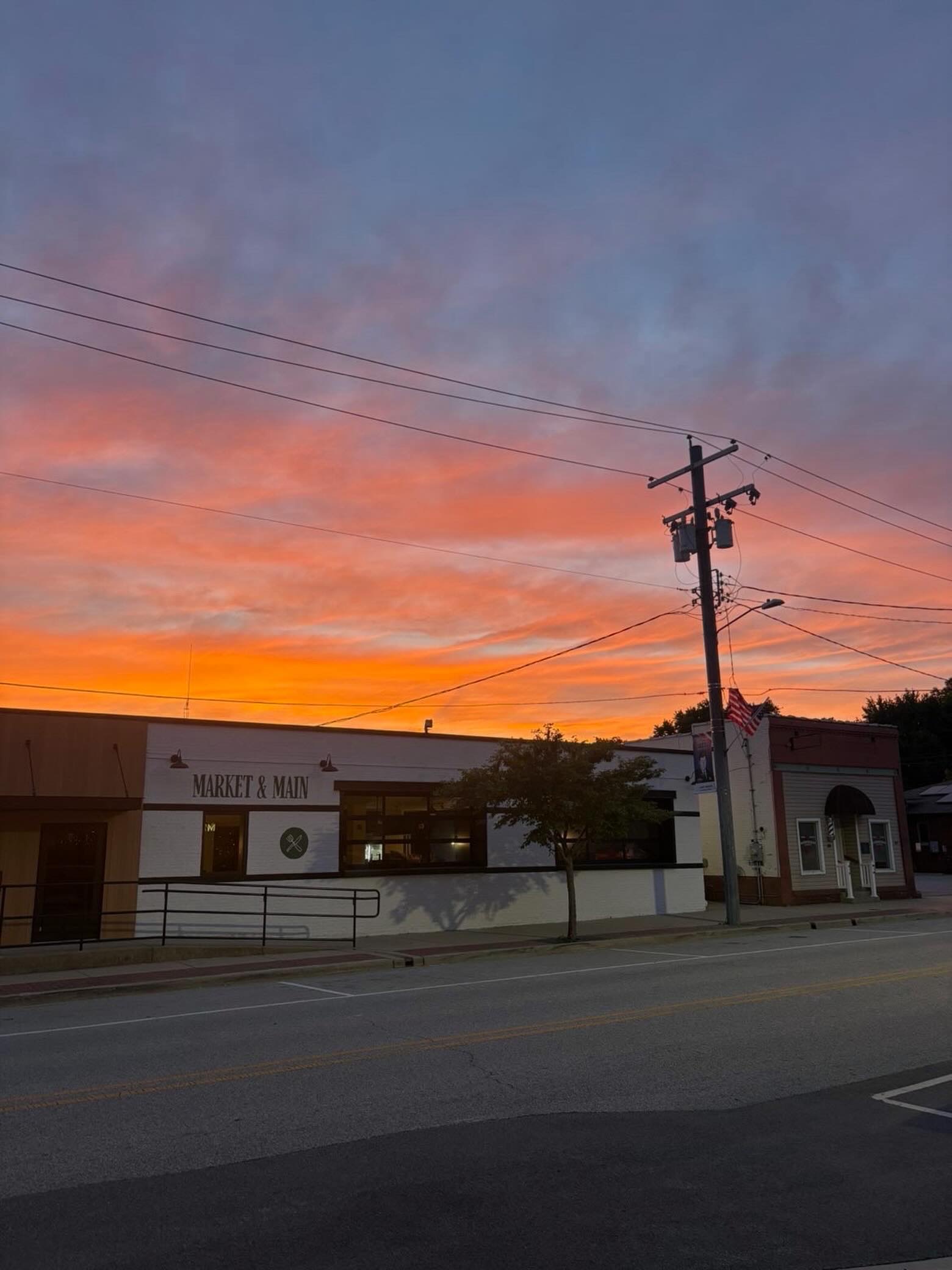Market & Main storefront on Main Street in Troy under a sunset sky